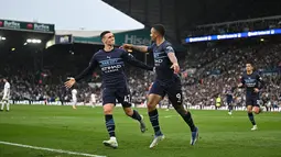 Striker Manchester City, Gabriel Jesus (tengah) berselebrasi dengan gelandang Phil Foden setelah mencetak gol ke gawang Leeds United pada pertandingan lanjutan Liga Inggris di Elland Road di Leeds, Inggris utara (30/4/2022). The Citizens yang mengoleksi 83 poin berada di atas The Reds dengan 82 poin. (AFP/Oli Scarff)