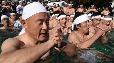 Penganut Shinto berdoa di kolam renang es untuk memurnikan tubuh dan jiwa dalam ritual Upacara Penyucian di Tokyo, Minggu (10/01/2016). (AFP Photo/ Toru Yamanaka)