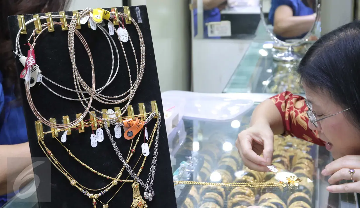Calon pembeli melihat emas di pusat penjualan emas kawasan Cikini, Jakarta, Senin (12/10/2015). Harga emas yang dijual PT Antam Tbk hari ini turun Rp11.000 ke Rp556.000 per gram dari sebelumnya Rp567.000 per gram. (Liputan6.com/Angga Yuniar)