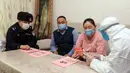 Petugas polisi dan tenaga medis saat mensosialisasikan bahaya virus corona atau COVID-19 kepada warga di Altay, wilayah Xinjiang, China (19/2/2020). Hingga Sabtu (22/2/2020), jumlah kasus yang terkonfirmasi infeksi virus corona Covid-19 sebanyak 76.806 dengan kasus kematian sebanyak 2.250. (AFP/STR)