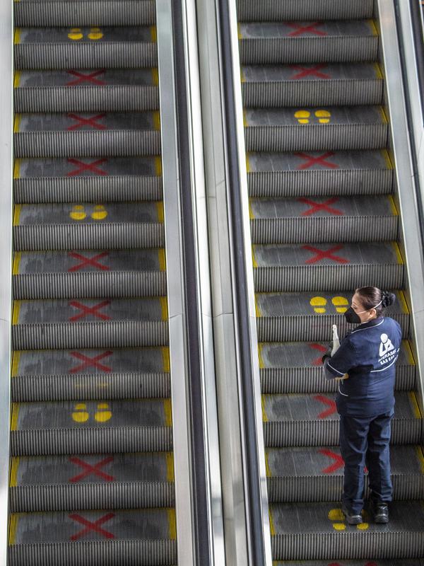Seorang pekerja menggunakan eskalator di Bandara Internasional El Dorado, Bogota, Kolombia, Senin (31/8/2020). Presiden Kolombia Ivan Duque mengizinkan lebih banyak penerbangan domestik mulai September. (Juan BARRETO/AFP)