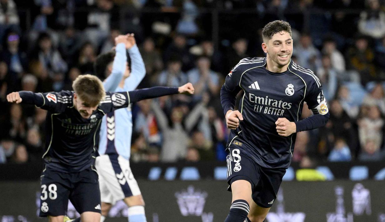 Kemenangan ini memastikan persaingan perebutan gelar juara La Liga 2025/2026 tetap sengit. Saat ini Real Madrid berada di posisi dua klasemen dengan 63 poin. Tampak dalam foto, gelandang Real Madrid asal Uruguay, Federico Valverde (kanan), merayakan golnya pada pertandingan pekan ke-27 La Liga 2025/2026 melawan Celta Vigo di Estadio Abanca-Balaidos pada Jumat 6 Maret 2026 waktu setempat atau Sabtu 7 Maret 2026 dini hari WIB. (Miguel RIOPA/AFP)
