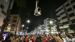 Para pendukung Maroko merayakan kemenangan negaranya atas Portugal pada babak 8 besar Piala Dunia 2022, di ibu kota Rabat, Sabtu (10/12/2022). Jutaan rakyat Maroko bergembira merayakan kemenangan bersejarah Timnas Maroko atas Portugal di Piala Dunia 2022. (FADEL SENNA / AFP)