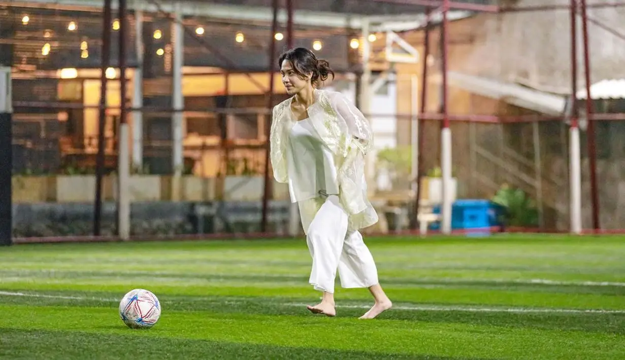 Tanpa alas kaki, Azizah hanya mengenakan atasan dan celana kulot serba putih yang dipadukan dengan lace outer warna broken white. Wajahnya dipulas makeup natural, sementara rambutnya ditata model updo.  [@acadumpie/@arhanzize__]