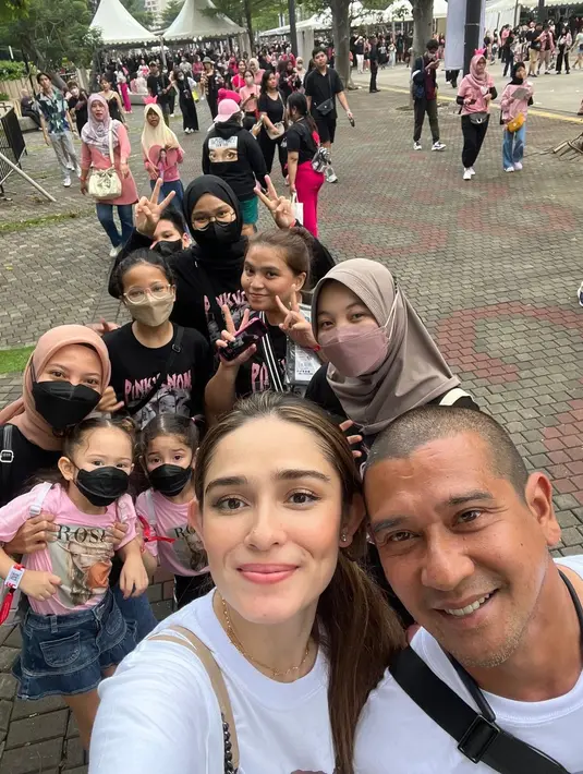 Kedua putrinya tampak mengenakan kaos merah muda, sedangkan pasangan yang menikah sejak tahun 2013 ini kompak mengenakan kaos putih. Mengabadikan momen sebelum masuk dengan penggemar Blackpink. [Foto; Instagram/yaswildblood]