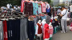 Pengunjung memilih barang saat pelaksanaan car free day di sepanjang Jalan Sudirman, Jakarta, Minggu (1/7). Kurangnya pengawasan menyebabkan banyak PKL yang berjualan tidak pada tempatnya dan memenuhi area CFD. (Liputan6.com/Immanuel Antonius)