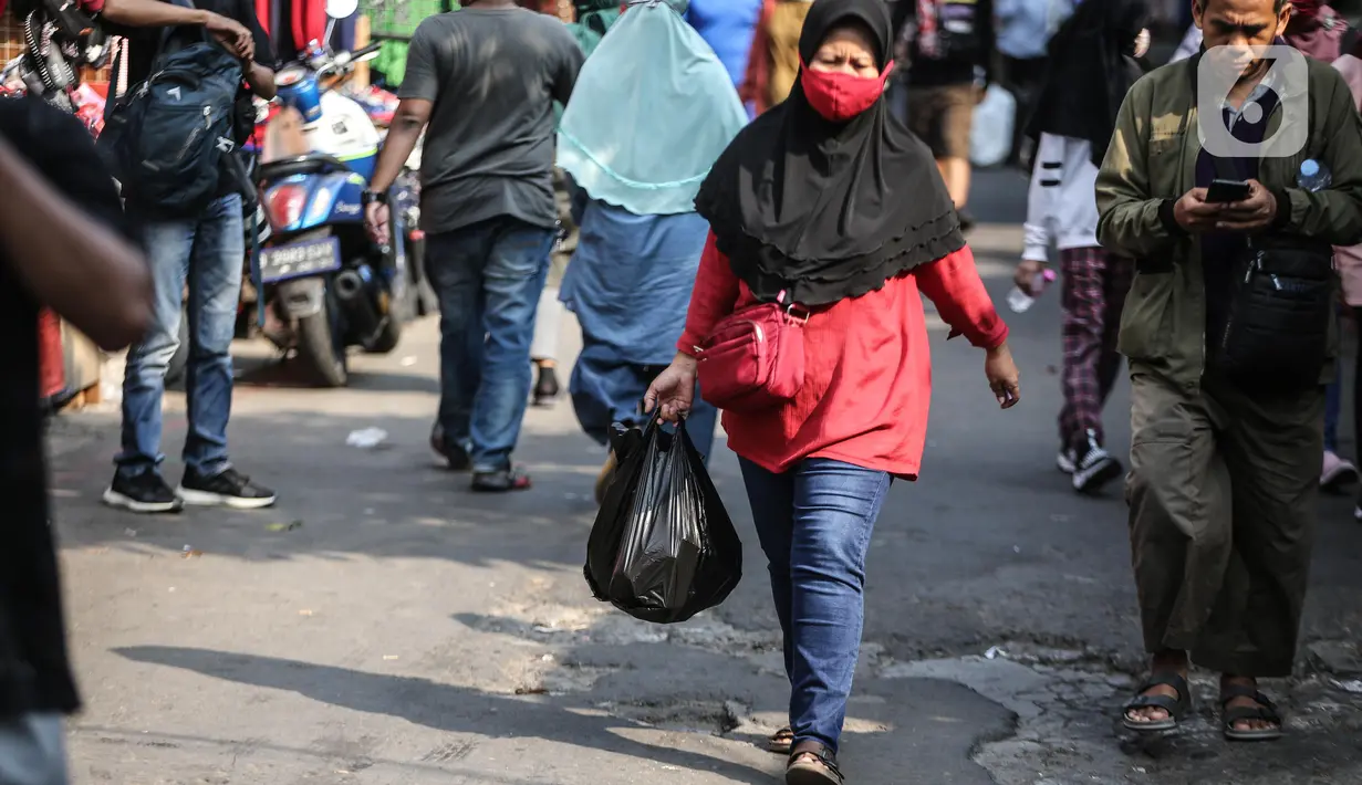 Warga membawa barang belanjaan dengan menggunakan kantong plastik di Kawasan Pasar Jatinegara, Jakarta, Selasa (30/6/2020). Pemerintah Provinsi DKI Jakarta bakal resmi menerapkan larangan penggunaan kantong plastik sekali pakai mulai Rabu, 1 Juli 2020 besok. (Liputan6.com/Faizal Fanani)