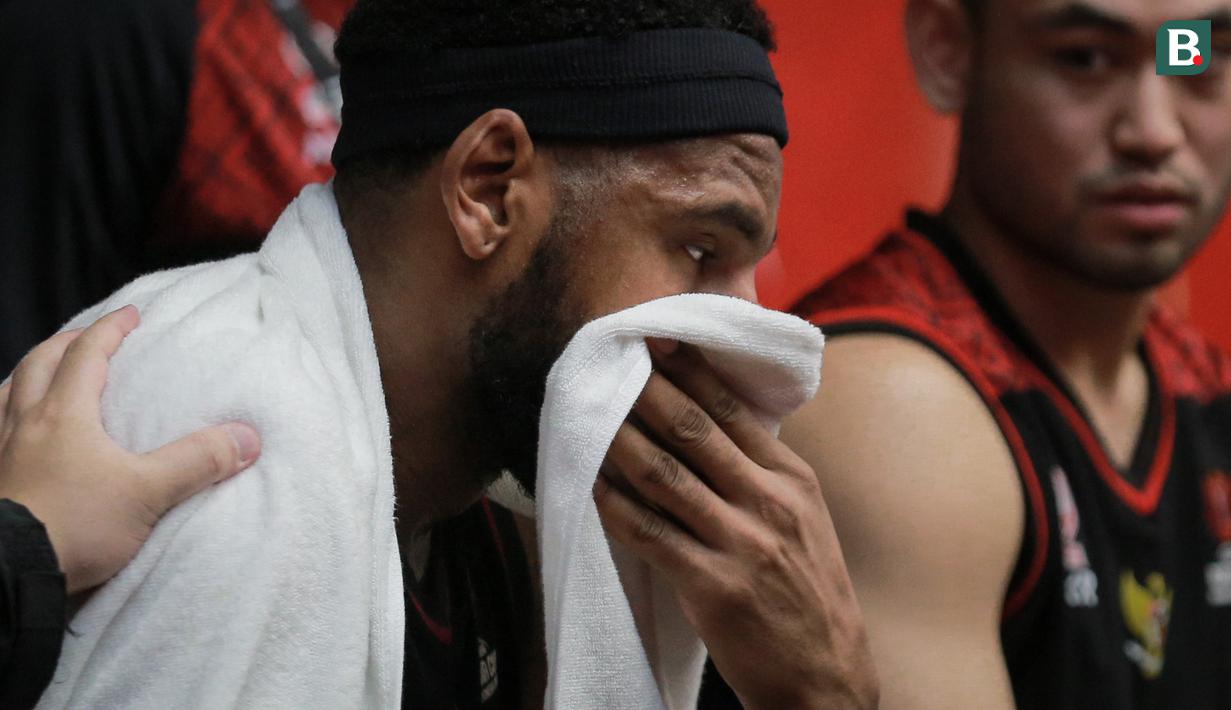 Pemain Timnas Basket Indonesia, Marques Tarrell Bolden menyeka mukanya dengan handuk saat laga playoff perempat final FIBA Asia Cup 2022 antara Timnas Basket China melawan Timnas Basket Indonesia di Istora Senayan, Jakarta, Senin (18/07/2022). (Bola.com/Bagaskara Lazuardi)