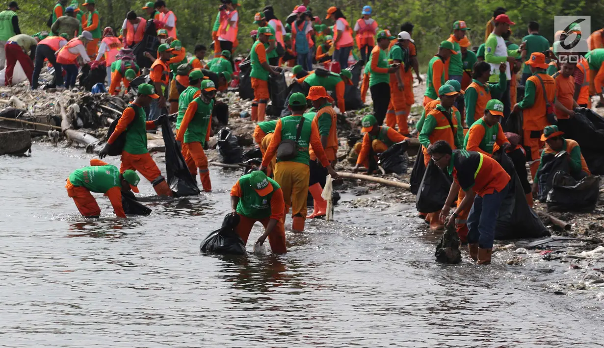 Petugas mengangkut sampah di Pesisir Teluk Jakarta, Cilincing, Jakarta Utara, Minggu (15/4). Kegiatan ini melibatkan unsur masyarakat di antaranya, dari Kementerian LHK RI, SKPD, Polri, TNI, LSM serta tokoh masyarakat. (Liputan6.com/Arya Manggala)