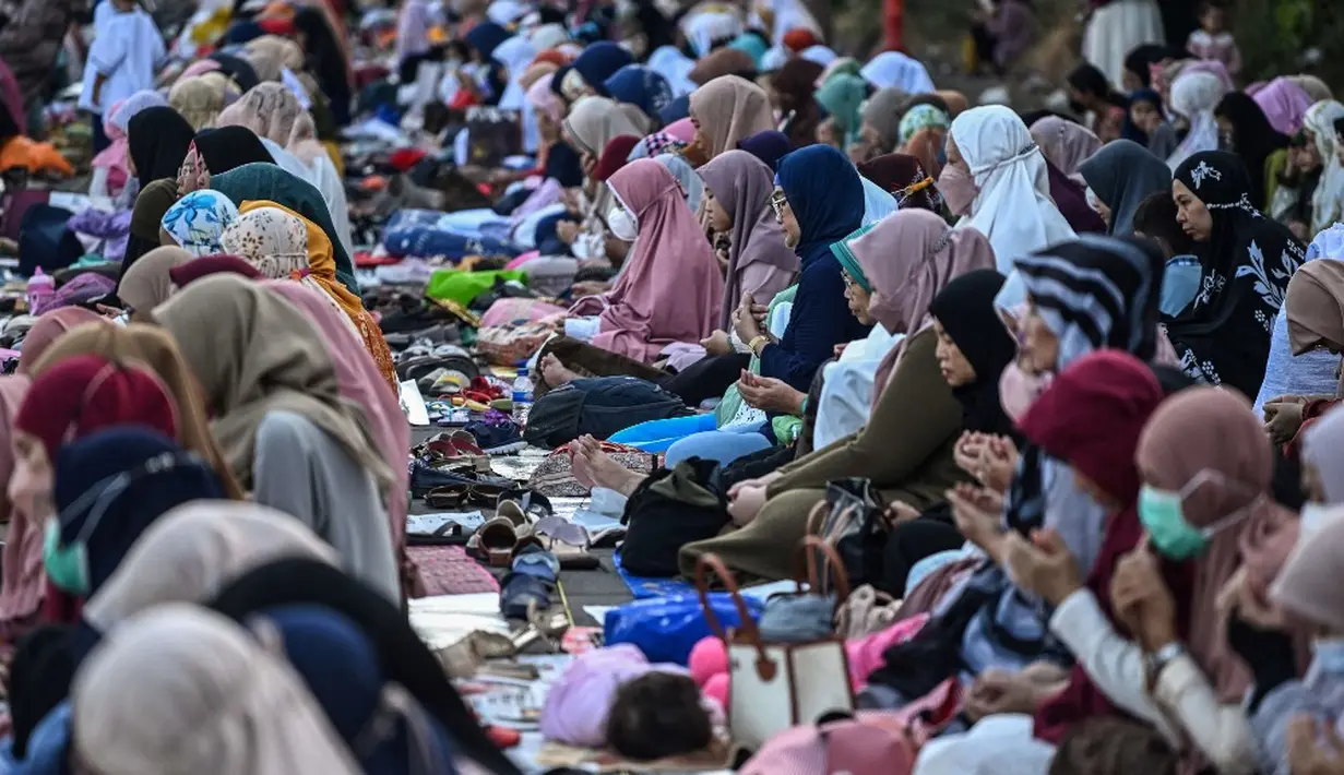 <p>Mereka berduyun-duyun mencapai lokasi sambil membawa peralatan sholat. (JUNI KRISWANTO/AFP)</p>