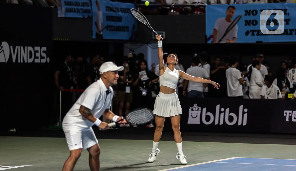 Pasangan ganda campuran Gading Marten/Wulan Guritno saat melawan Dion Wiyoko/Enzy Storia (kanan) pada pertandingan pembuka Tiba Tiba Tenis di Tennis Indoor Senayan, Jakarta, Sabtu (12/11/2022). Pasangan Dion Wiyoko/Enzy Storia berhasil mengalahkan Gading Marten/Wulan Guritno dua set langsung dengan skor meyakinkan, 6-2 dan 6-3. (Liputan6.com/Johan Tallo)