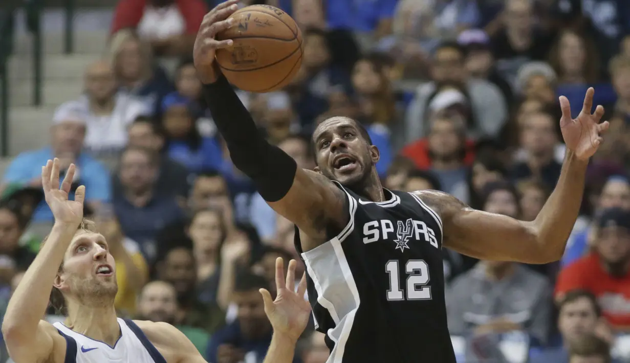 Pemain San Antonio Spurs, LaMarcus Aldridge (12) menghalau bola dari kejaran pemain Dallas Mavericks, Dirk Nowitzki (41) pada laga NBA Basketball game di American Airlines Center, Dallas, (14/11/2017). Spurs menang 97-91. (AP/LM Otero)