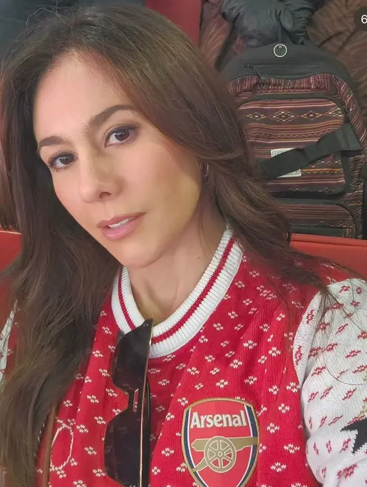 Saat berkunjung ke Inggris, Wulan Guritno tampil mengenakan knitwear merah dari club bola Arsenal. [@wulanguritno]
