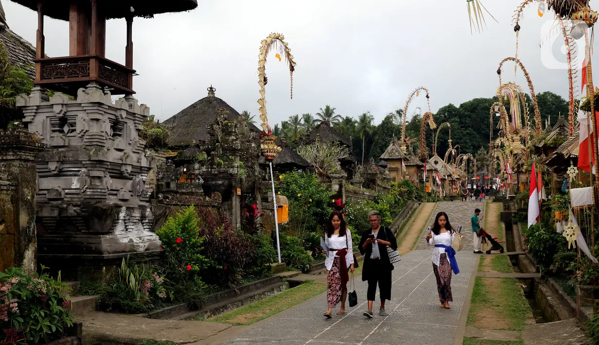 <p>Wisatawan berjalan menyusuri kawasan Desa Penglipuran di Kabupaten Bangli, Bali, Rabu (16/8/2023). (Liputan6.com/Helmi Fithriansyah)</p>