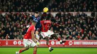 Bek Nottingham Forest, Ola Aina, melompat untuk menyundul bola saat berduel dengan gelandang Arsenal, Gabriel Martinelli, dalam pertandingan Liga Inggris antara Nottingham Forest dan Arsenal di The City Ground, Nottingham, Inggris bagian tengah, pada 17 Januari 2026. (AFP/Justin Talis)