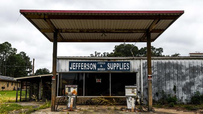 Sebuah pompa bensin sepi terlihat di Fayette, Jefferson County, Mississippi (28/9/2020). Sisa-sisa perkebunan kapas yang berdiri di sana adalah bangunan rapuh yang tersembunyi di antara tumbuhan lebat. (AFP/Chandan Khanna)