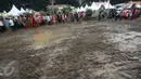 Pengunjung menghindari jalan yang becek pada Festival Lebaran Betawi IX, Jakarta, (14/8). Festival diramaikan dengan rumah adat Betawi dari masing-masing pemkot  administrasi Jakarta serta Kabupaten Kepulauan Seribu. (Liputan6.com/Immanuel Antonius)