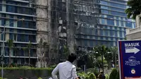 Penghuni apartemen memperhatikan Gedung Neo Soho pasca kebakaran di Tanjung Duren, Jakarta, Kamis (10/11). Hingga kini penyebab kebakaran belum diketahui dan masih dalam tahap penyelidikan. (Liputan6.com/Gempur M. Surya)