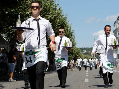 Sejumlah pramusaji beradu ketangkasan dalam Waiters Race ke-21 di Fetes de Geneve, Swiss, 6 Agustus 2017. Peserta diminta unjuk kebolehan menggunakan satu tangan membawa nampan berisi dua gelas dan dua botol penuh air. (Salvatore Di Nolfi/Keystone via AP)