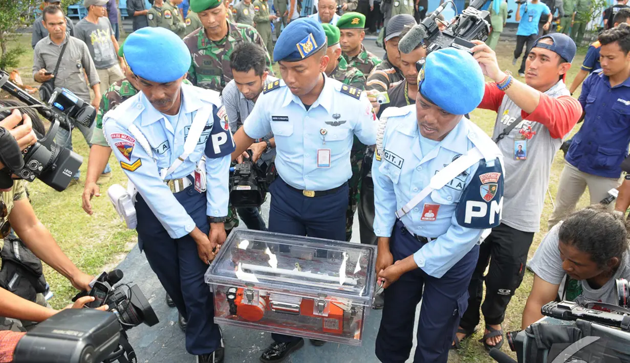 Petugas membawa FDR (Flight Data Recorde) ke pesawat Boeing untuk dibawa ke Jakarta dan diselidiki lebih lanjut, Lanud Iskandar, Pangkalan Bun, Kalteng, Senin (12/1/2015). (Liputan6.com/Andrian M Tunay)