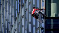 Alain Robert yang dikenal sebagai 'Spiderman Prancis' memanjat gedung pencakar langit Skyper di pusat Frankfurt, Jerman, 23 November 2021. Alain Robert telah memanjat lebih dari 100 bangunan dalam 30 tahun karirnya dan ditangkap puluhan kali. (AP Photo/Michael Probst)