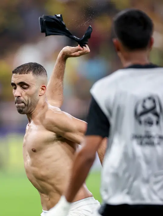 Pemain Al Ittihad, Abderazak Hamdallah melepas bajunya saat merayakan gol ke gawang Al Quwa Al Jawiya pada laga Grup C Liga Champions Asia 2023 di King Abdullah Sports City, Selasa (24/10/2023) dini hari WIB. Kemenangan 1-0 Al Ittihad membuat mereka kini bertengger di puncak klasemen grup sementara. (AFP)