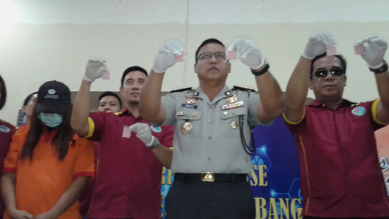 Satres Narkoba Polresta Palembang menunjukkan barang bukti berupa ratusan ekstasi yang dijual Fitri (Liputan6.com/Nefri Inge)