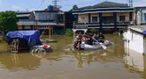 Para pemuda mengevakuasi warga saat banjir menggenangi kawasan RT 02/06, Kelurahan Petir, Kota Tangerang, Banten, Selasa (8/7/2025). (merdeka.com/Arie Basuki)