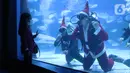 Seorang anak menyaksikan penyelam berkostum sinterklas di dalam air yang dihiasi pohon natal di Jakarta Aquarium dan Safari, Mal Neo Soho, Grogol, Jakarta, Kamias (24/12/2020). (Liputan6.com/Angga Yuniar)