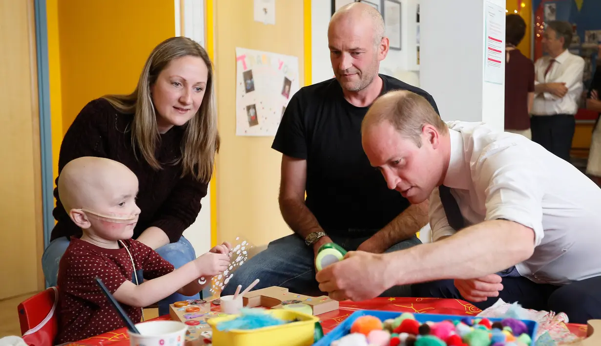 Pangeran William bermain dengan anak pengidap kanker, Charlie Miller saat mengunjungi rumah sakit Royal Marsden di London, Selasa (16/5). Dalam kunjungannya, Pangeran William menghibur sejumlah pasien anak pengidap kanker. (Kirsty Wigglesworth /POOL/AFP)