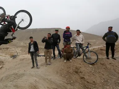 Aksi pemuda Afghanistan saat melakukan lompatan disaksikan para temannya saat mengendarai sepeda Dirt Jump (DJ) di Kabul, Afghanistan (20/11). Sepeda jenis ini awalnya dirancang untuk anak muda perkotaan, sebagai alat transportasi. (Reuters/Omar Sobhani)