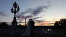 Sepasang calon pengantin melakukan foto prewedding dengan latar belakang Pyramide de Louvre di Paris, 9 Juli 2017. Bukan cuma menara Eiffel yang sudah amat terkenal itu, ibukota Perancis ini juga punya Piramida Louvre. (AFP PHOTO / LUDOVIC MARIN)