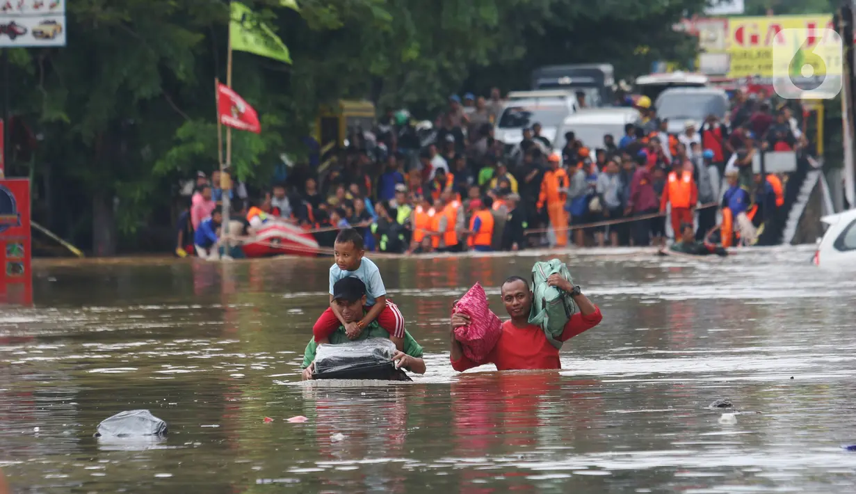Warga melintasi banjir  yang merendam jalan Raya KH Hasyim Ashari, Ciledug ,Tangerang, Rabu (1/1/2020). Banjir setinggi dada orang dewasa membuat jalur penghubung Tangerang ke Jakarta tersebut terputus tidak dapat dilintasi. (Liputan6.com/Angga Yuniar)