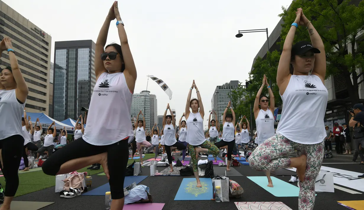 Para peserta ambil bagian dalam acara yoga massal untuk memperingati Hari Yoga Internasional yang jatuh pada 21 Juni di Alun-Alun Gwanghwamun, Seoul, Korea Selatan, Minggu (17/6). (AFP PHOTO/Jung Yeon-je)
