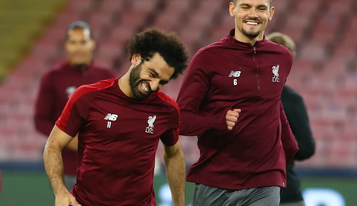 Pemain Liverpool, Dejan Lovren dan Mohamed Salah tertawa selama sesi latihan di stadion San Paolo di Naples, Italia (2/10). Liverpool akan bertanding melawan Napoli pada grup C Liga Champions. (AFP Photo/Carlo Hermann)