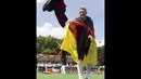 Pemain Timnas Jerman, Bastian Schweinsteiger, melemparkan kaos ke arah para suporter yang ikut merayakan kemenangan Der Panzer, Berlin, (15/7/2014). (REUTERS/Axel Schmidt)