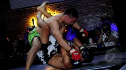 Aksi saling menjatuhkan lawan mewarnai  XXC Championship 2015 yang dihelat di Embrio Markas Cafe, Jakarta, Minggu (12/04/15). XCC Championship 2015 salah satu olah raga bela diri MMA (Mixed Matrial Arts). (Liputan6.com/Faisal R Syam)