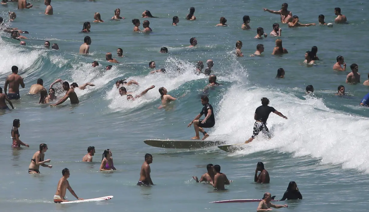 Warga Australia menghabiskan waktunya bermain dipantai Bondi Sydney selama gelombang panas yang melanda wilayah Australia, (20/11/2015). Akibat suhu yang panas, mayoritas warga Australia mengabiskan waktunya dipantai. (REUTERS/Jason Reed)