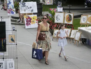 Sejumlah orang mengamati karya seni yang dipajang di area terbuka dalam pameran Art Downtown, Vancouver, British Columbia, Kanada, 4 September 2020. Art Downtown merupakan proyek yang memungkinkan seniman dan publik saling terhubung dan menginspirasi serta berbagi kreativitas. (Xinhua/Liang Sen)