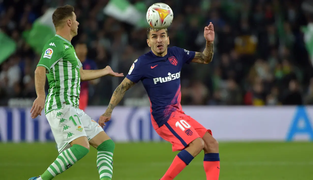 Gelandang Real Betis Joaquin (kiri) berebut bola dengan penyerang Atletico Madrid Angel Correa pada laga Pekan Ke-27 La Liga Spanyol di Estadio Benito Villamarin, Sevilla, Senin (7/3/2022) dini hari WIB. Atletico Madrid menang 3-1 atas Real Betis. (CRISTINA QUICLER / AFP)