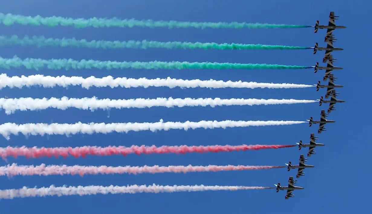 Aksi tim aerobatik Frecce Tricolori terbang mengeluarkan asap berwarna bendera Italia selama parade militer ulang tahun Hari Republik Italia ke-72 di Roma, Sabtu (2/6). (AP Photo/Claudio Peri)