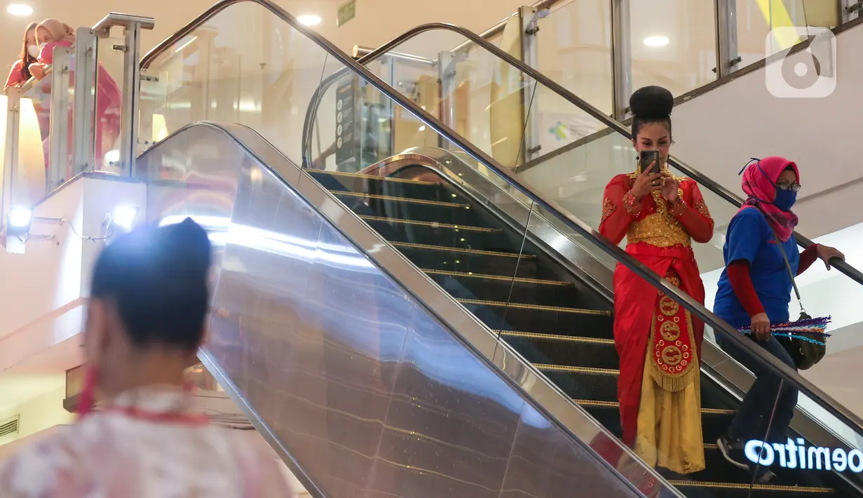 Pengunjung mengabadikan model dengan busana kain serat alami pada Ecoprint Fashion Week 2022 di The Plaza Semanggi, Jakarta, Rabu (06/4/2022). Kegiatan yang melibatkan UMKM digelar hingga 10 April 2022 menampilkan 37 desainer mulai dari helaian kain ecoprint hingga topi. (Liputan6.com/Fery Pradolo)