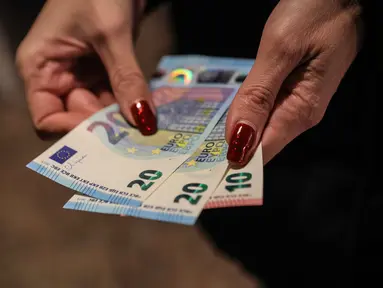 Seseorang menunjukkan uang kertas euro yang ditarik dari ATM di Sofia, Bulgaria, Kamis 1 Januari 2026, saat negara tersebut bergabung dengan serikat mata uang euro. Bulgaria resmi memasuki era baru kebijakan moneter dengan mengadopsi euro sebagai mata uang nasional. (AP Photo/Valentina Petrova)