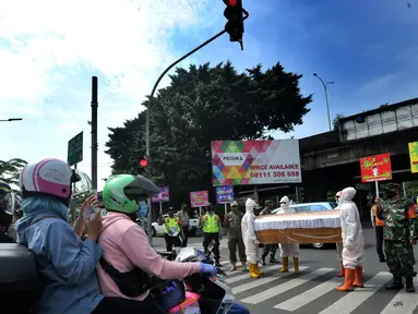 Petugas Gabungan membawa peti mati di hadapan pengendara bermotor di perempatan Fatmawati, Jakarta Selatan, Kamis (3/9/2020). Kegiatan berkeliling membawa peti jenasah tersebut dilakukan oleh petugas gabungan dari wilayah Kecamatan Cilandak. (merdeka.com/Arie Basuki)