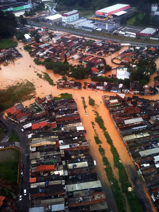 Foto dari atas memperlihatkan banjir yang melanda wilayah Itapevi, sekitar 41 km dari Sao Paulo, Brasil, Jumat (11/3). Hujan deras yang mengakibatkan banjir dan longsor tersebut menewaskan sedikitnya 19 orang. (AFP PHOTO/Marcel Naves)