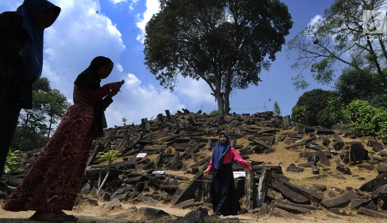 Pengunjung berfoto di kawasan Situs Megalitikum Gunung Padang, Kabupaten Cianjur, Jawa Barat, Minggu (11/8/2019). Libur Idul Adha 2019 dimanfaatkan warga sekitar Jabotabek dan Bandung untuk mengunjung situs megalitik terbesar di Asia Tenggara tersebut. (merdeka.com/Arie Basuki)