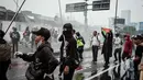 Aparat juga menembakkan water cannon untuk membubarkan aksi unjuk rasa. (YASUYOSHI CHIBA/AFP)
