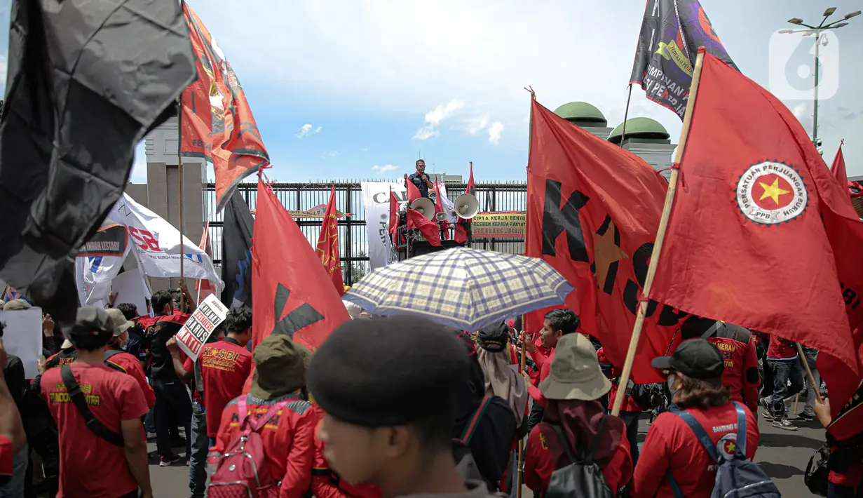 Elemen buruh menggelar aksi unjuk rasa di gedung DPR RI, Jakarta, Selasa (10/1/2023). Di tengah terik, mereka berorasi dan mengajak agar seluruhnya merapat ke depan gerbang DPR/MPR RI. (Liputan6.com/Faizal Fanani)