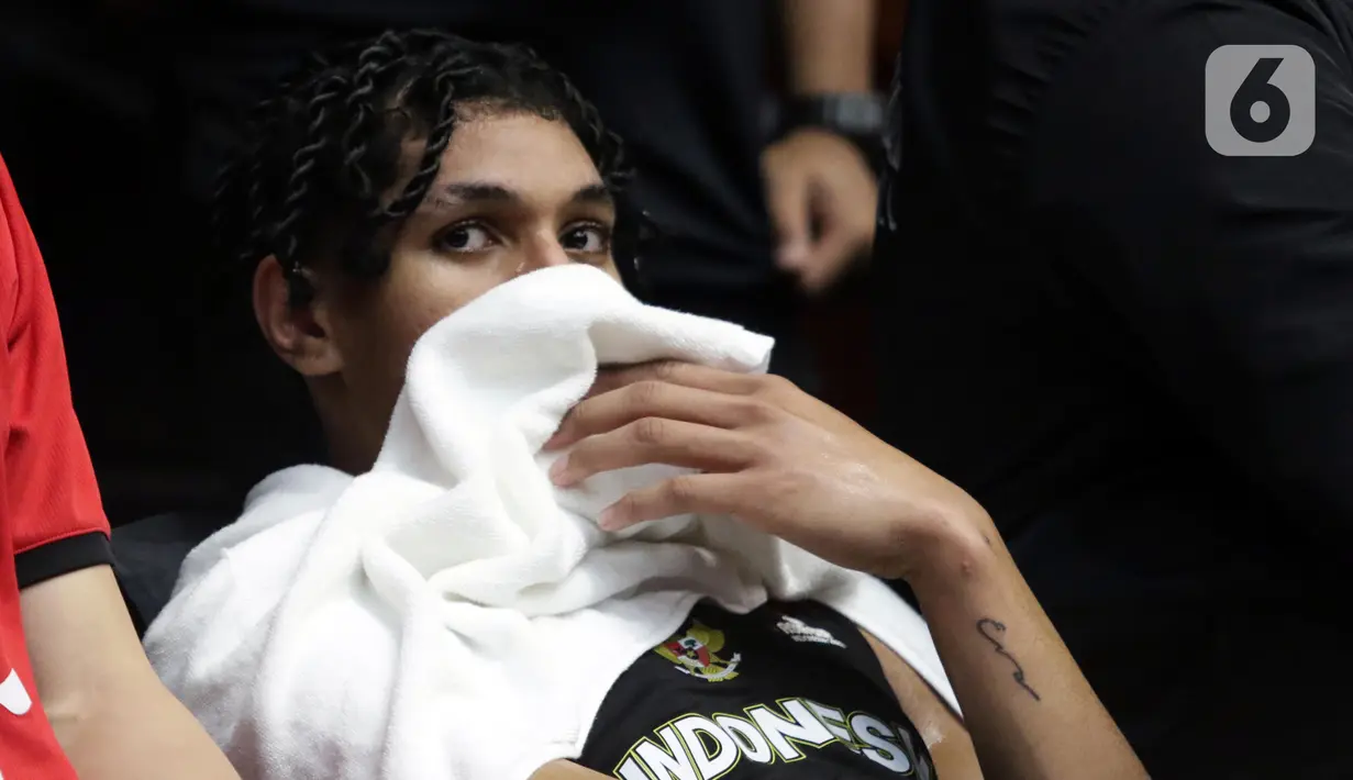 Pebasket Timnas Indonesia, Derrick Michael Xavierro beristirahat di bangku cadangan saat melawan China pada laga playoff perempat final FIBA Asia Cup 2022 di Istora Senayan, Jakarta, Senin (18/7/2022). Timnas basket Indonesia tersingkir dari ajang FIBA Asia Cup 2022 usai menelan kekalahan telak 58-108 dari China. (Liputan6.com/Helmi Fithriansyah)
