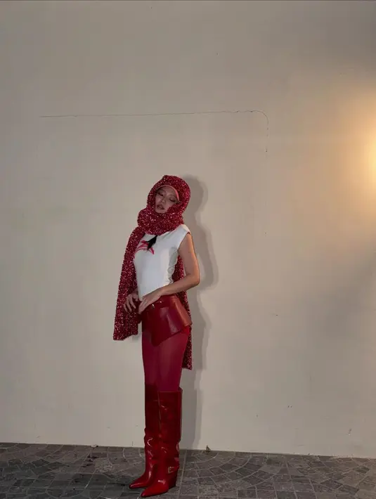 Dalam unggahan terbaru, Jennie berdiri anggun dalam balutan white tee berhiaskan ilustrasi merah. Ia memadukan kaos lengan pendeknya dengan rok kulit mini warna merah, serasi dengan stocking merah cerah. Sebuah sepatu merah yang chic pun melengkapi penampilannya.  [@jennierubyjane].